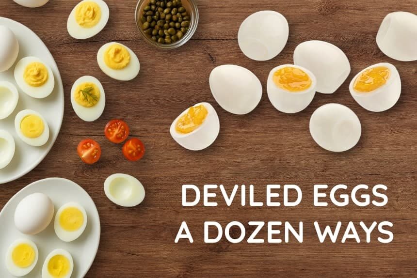 Hard-boiled eggs cut in half on a wooden table, some filled with classic deviled egg filling and others waiting to be prepared.